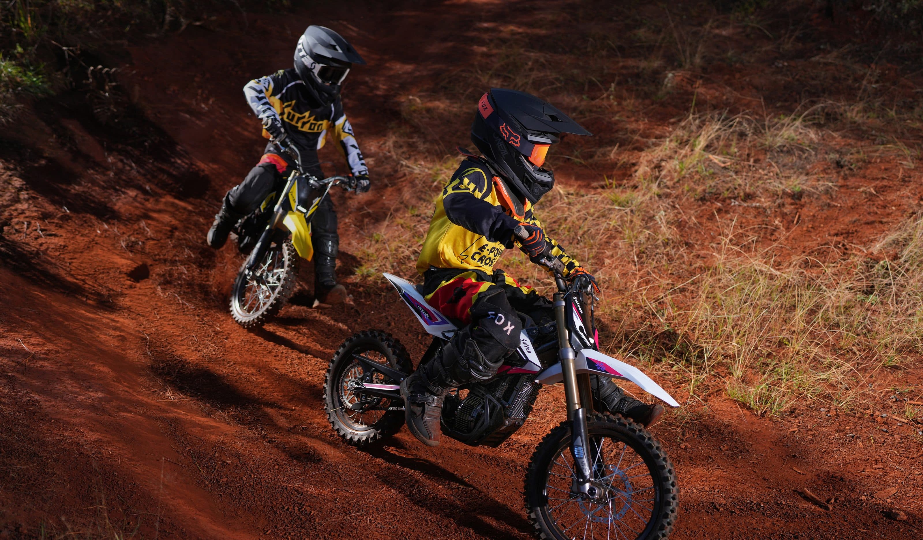 Two young riders on Hyper Bees on red dirt