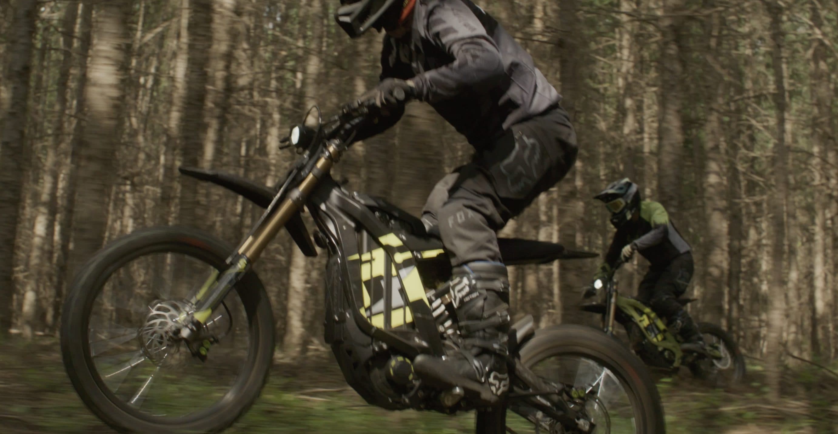 Two riders on Light Bee X bikes in a pine forest