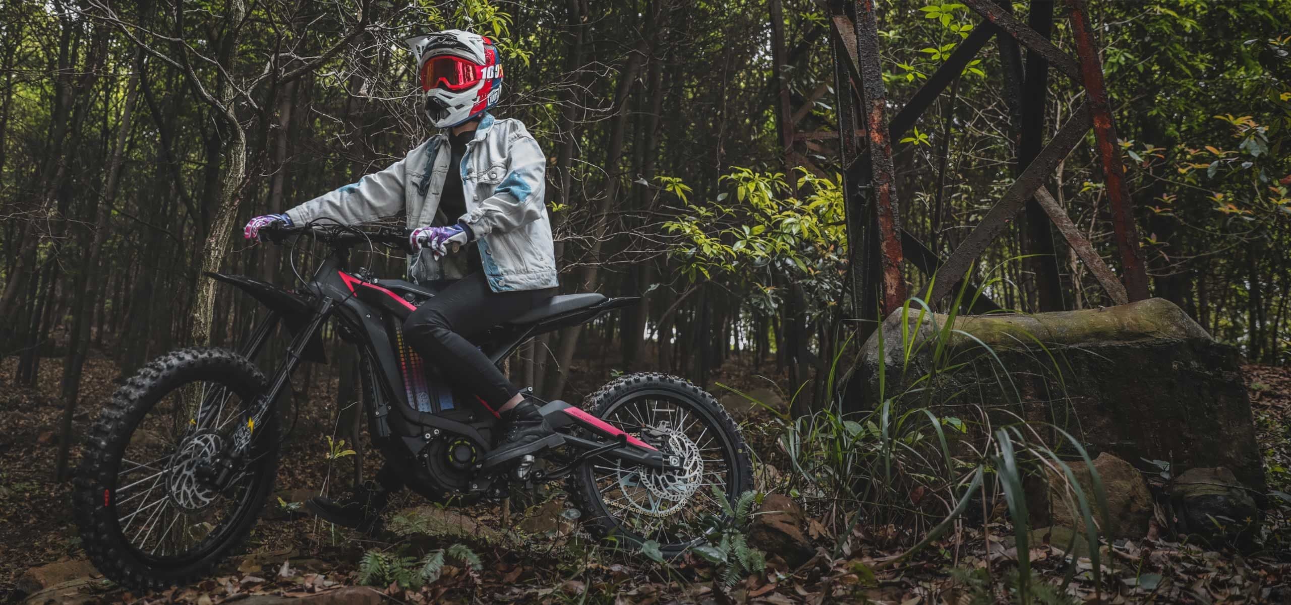 Rider standing over a Light Bee X in the woods